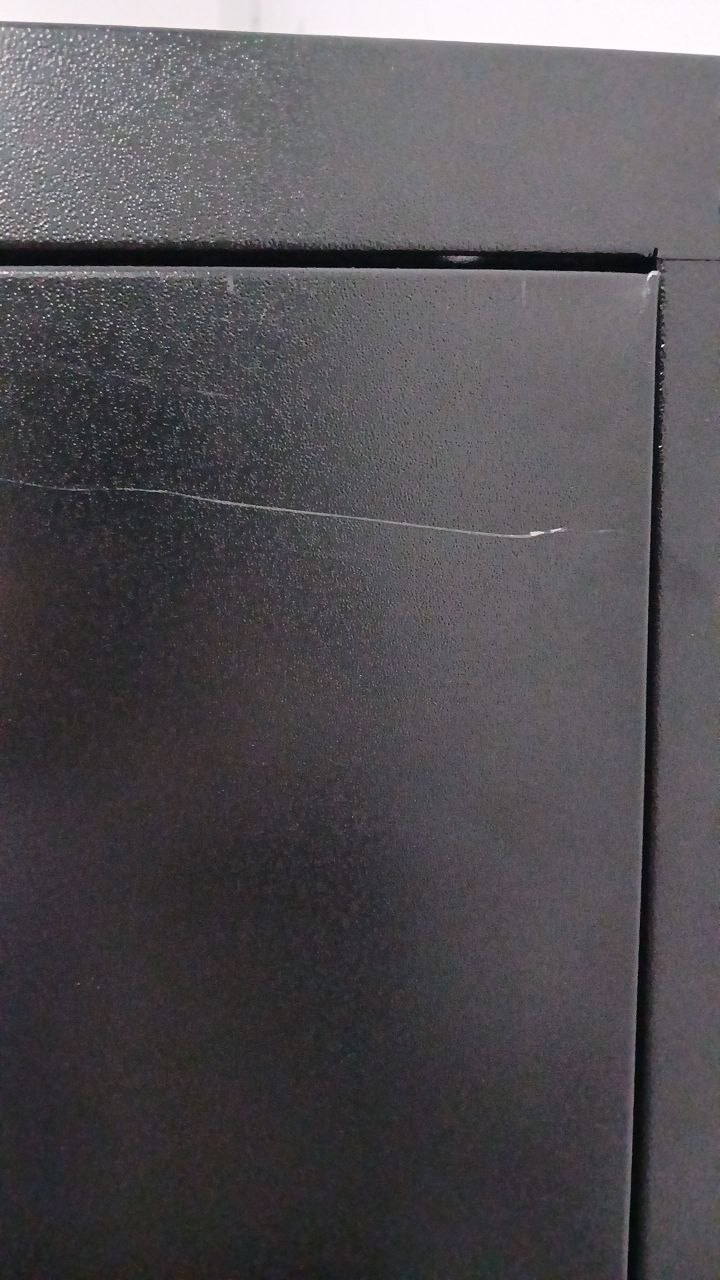 Canto de painel com risco visível na pintura e desalinhamento na junta entre painéis.