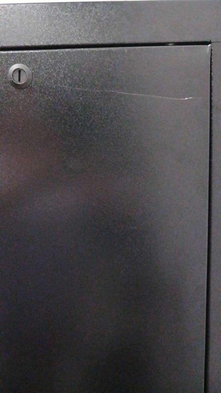 Painel próximo à fechadura, com risco na pintura e gap na junção dos painéis.